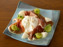  新鲜布拉塔奶酪配水果和意大利熏火腿 