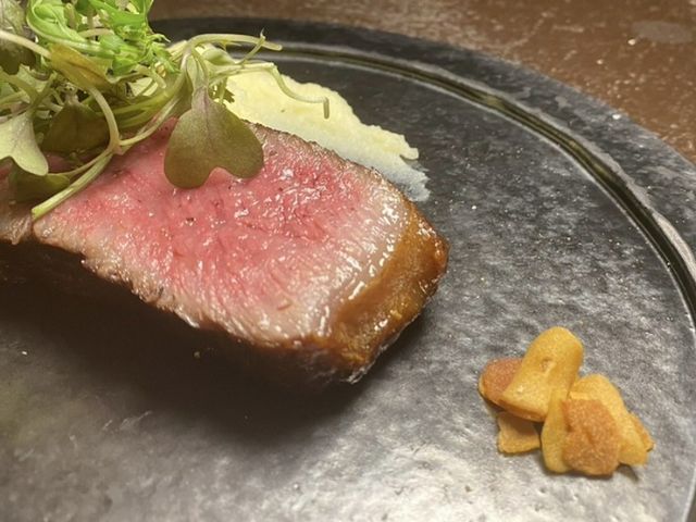 Savor Kobe beef steak grilled to perfection over charcoal, accompanied by wine